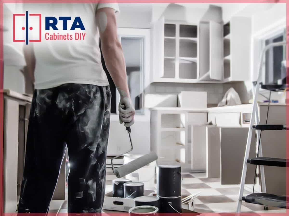 A person painting kitchen cabinets in a DIY home project.